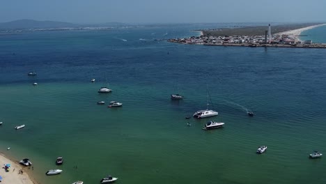 canal de agua entre la isla del faro y la isla desierta con barcos turísticos en el agua esmeralda, algarve