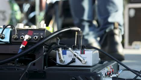 Guitarist-Switching-Pedalboard-During-An-Outdoor-Concert-At-Daytime