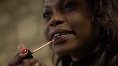 Slow-motion-selective-focus,-shallow-depth-of-field-applying-lipstick-black-woman-with-sensual-lips