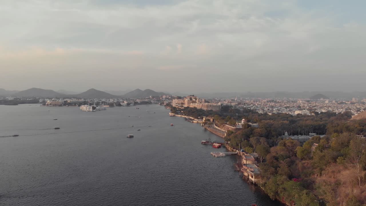 인도 라자스탄주 우다이푸르(udaipur), 라자스탄(rajasthan), 일몰 시 멀리 타지 호수 궁전(taj lake palace)이 있는 피콜라 호수(pichola lake bank)의 탁 트인 전망