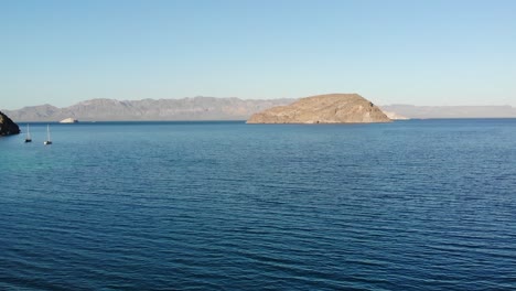 Taking-off-the-drone-from-Playa-El-Coyote,-with-a-view-of-its-blue-waters-and-Isla-Coyote-in-the-background,-BCS