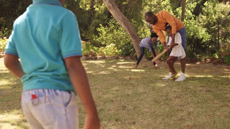 una familia linda está jugando al béisbol en un parque