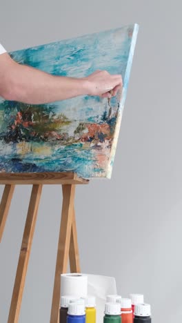 artist creating abstract painting on canvas