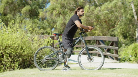 lado de un motociclista enfocado con discapacidad escribiendo un mensaje en el teléfono