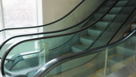 first-person perspective showing a side view of two escalators, one in operation and the other stationary