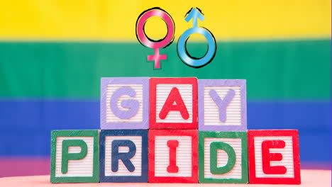 Animation-of-gay-pride-on-blocks-and-female-and-male-symbols-on-rainbow-background