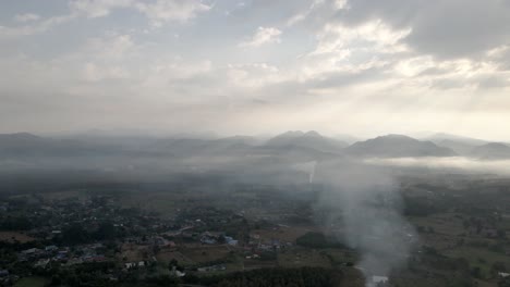 Sonnenschein-Durch-Die-Wolken-Bei-Sonnenaufgang-über-Dem-Nebligen-Dorf-Im-Norden-Thailands