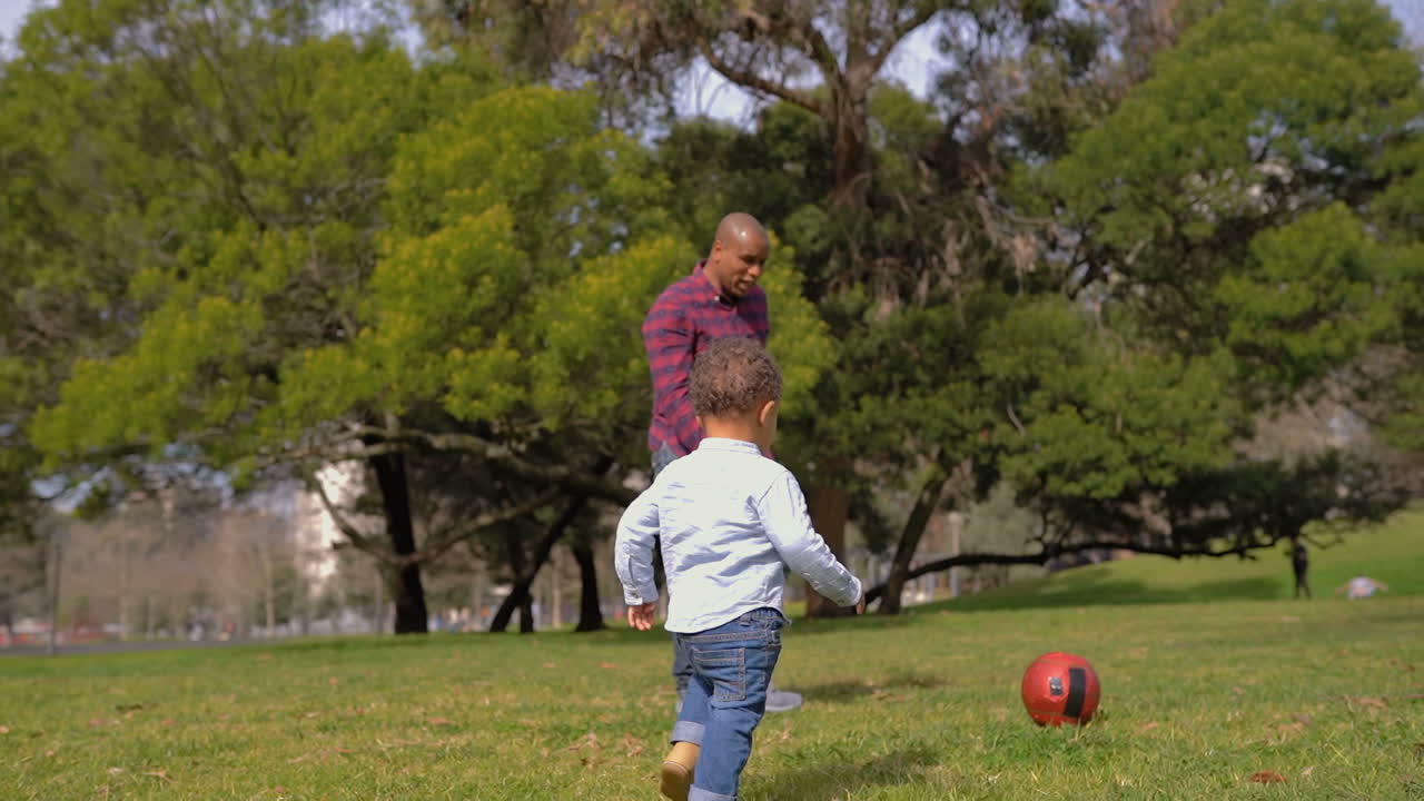 chico aplaudiendo, imitando a su padre, jugando al fútbol juntos