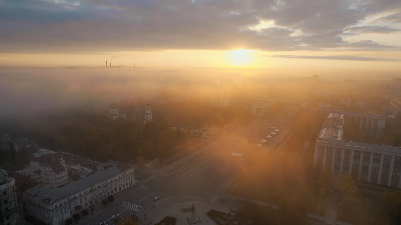 Aerial drone view of Chisinau at sunrise, Moldova. View of city centre covered with fog and low clouds. Central Park, Goverment building, main square with moving cars