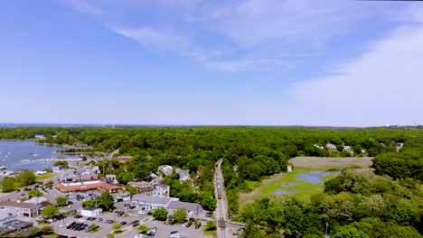 Angled-birds-eye-view-of-train-running-on-track-through-dense-greenery-adjacent-to-developed-urban-city