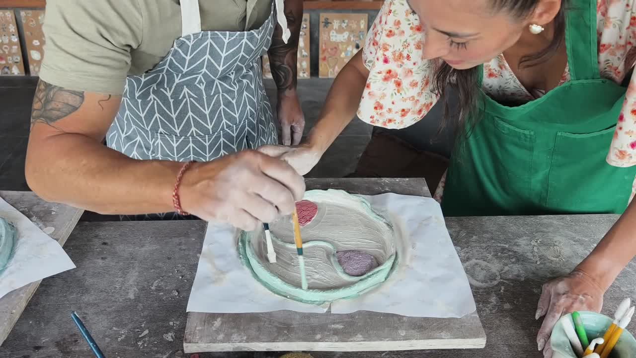 Pareja pintando cerámica en un taller de arte