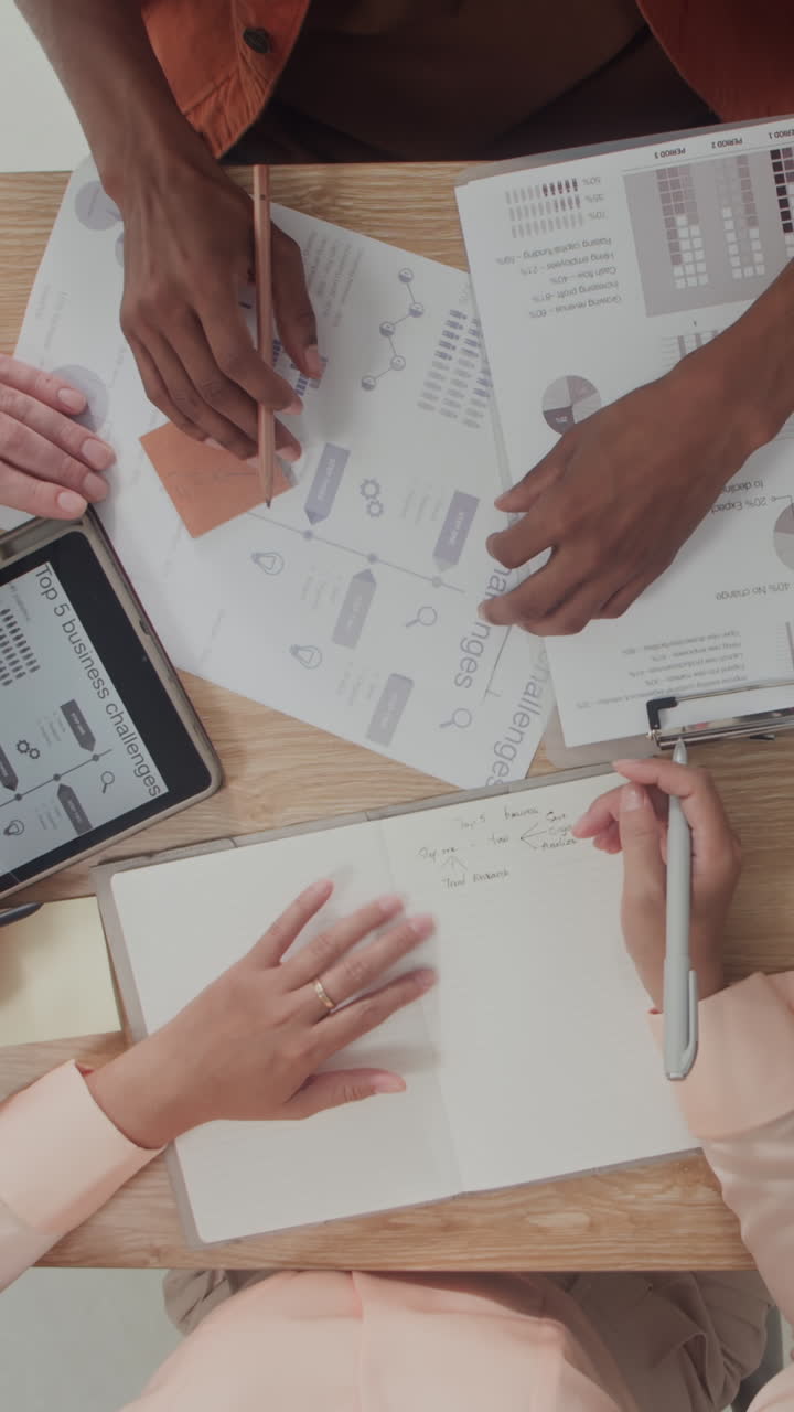 Unrecognizable Coworkers Discussing Documents at Table Top Down View