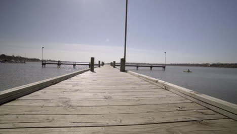 esta es una grabación de un kayakista pescando al final de un largo muelle