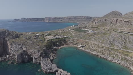 drone flies towards saint paul's bay in lindos, rhodes, greece. 4k filmed in d-log m profile, not graded.