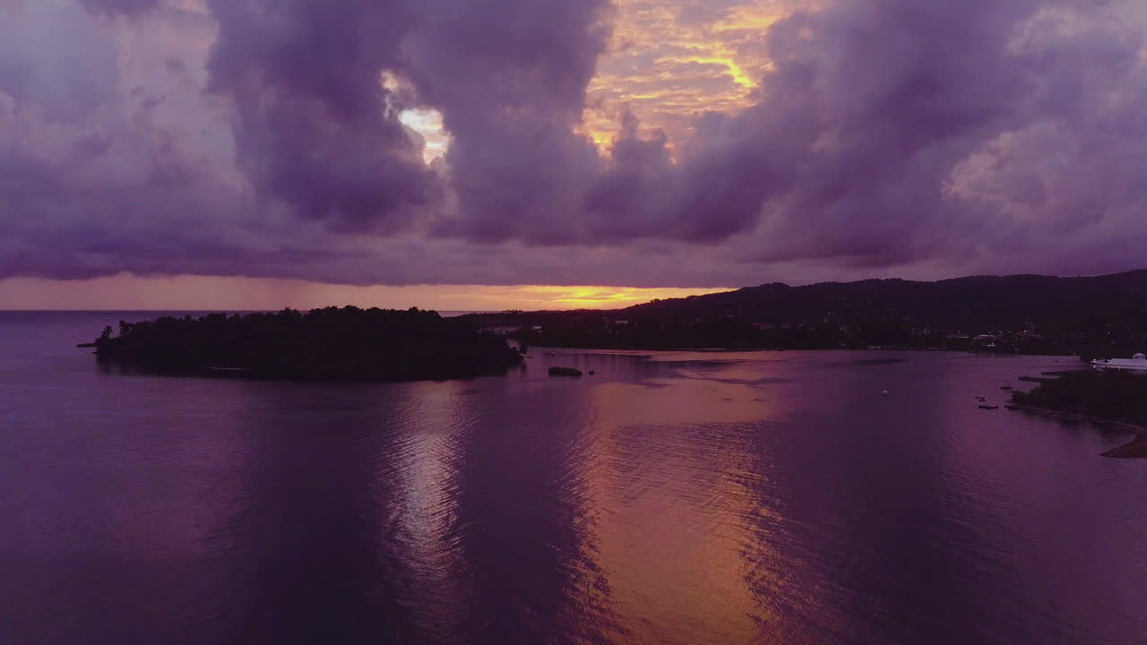 vista aérea del amanecer sobre la isla de la marina y el puerto este en port antonio en jamaica con cielos rosados y morados que se reflejan en el océano