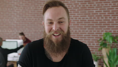 close-up-portrait-of-young-bearded-caucasian-man-entrepreneur-laughing-cheerful-male-in-modern-workspace-background-enjoying-success