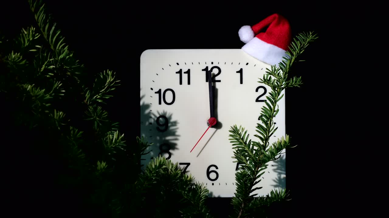 reloj en ramas de abeto de año nuevo en fondo negro. la manilla de segundos se mueve en círculo de reloj mecánico y muestra las doce en punto a medianoche y víspera de navidad. concepto de vacaciones, lapso de tiempo, primer plano, primer plano
