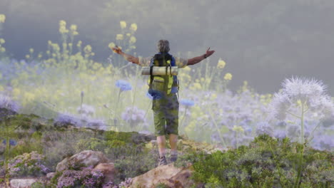 hombre mayor caucásico feliz caminando en el campo sobre flores silvestres moviéndose en el viento
