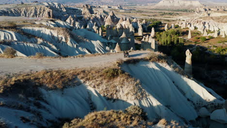 Mujer-Joven-Montando-Un-Quad-A-Través-Del-Terreno-Jurásico-De-Capadocia,-Turquía