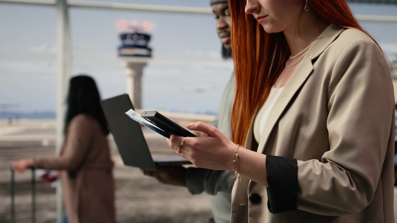Zbliżenie na mężczyznę i kobietę na lotnisku, korzystających z laptopa i smartfona