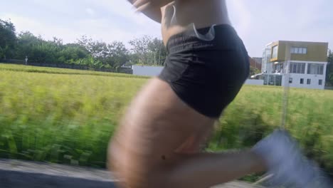 woman with earphones running along road