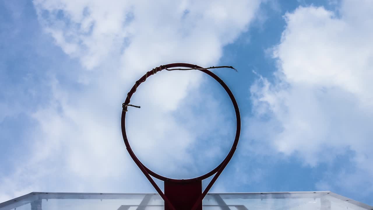 un aro de baloncesto con un fondo de nubes en movimiento