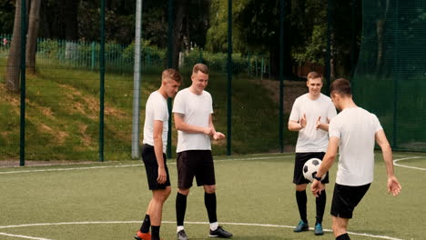 a young soccer man training freestyle tricks on a street football pitch while his team watching him