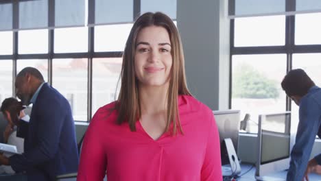 Businesswoman-looking-at-camera-in-modern-office