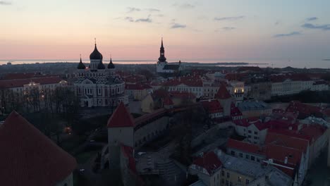 drone rising over tallinn walls and tower to old town with famous buildings