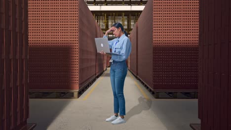 full body side view of asian female with her laptop with red brick packed in stacks are stored, typing and dissapionted with nodding her shead