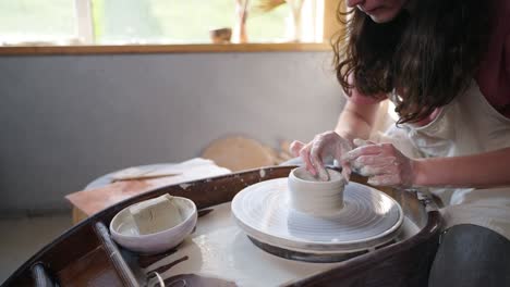 niña alfarera trabajando en un plato de arcilla