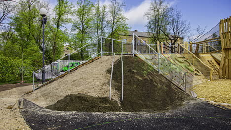 timelapse shot of workers cementing the slope of an elevated play house for kids in playground in a park at daytime