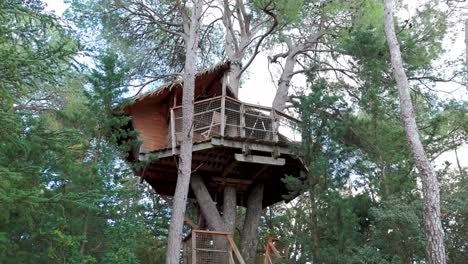 Slow-establishing-shot-of-a-handmade-treehouse-surrounded-by-a-forest