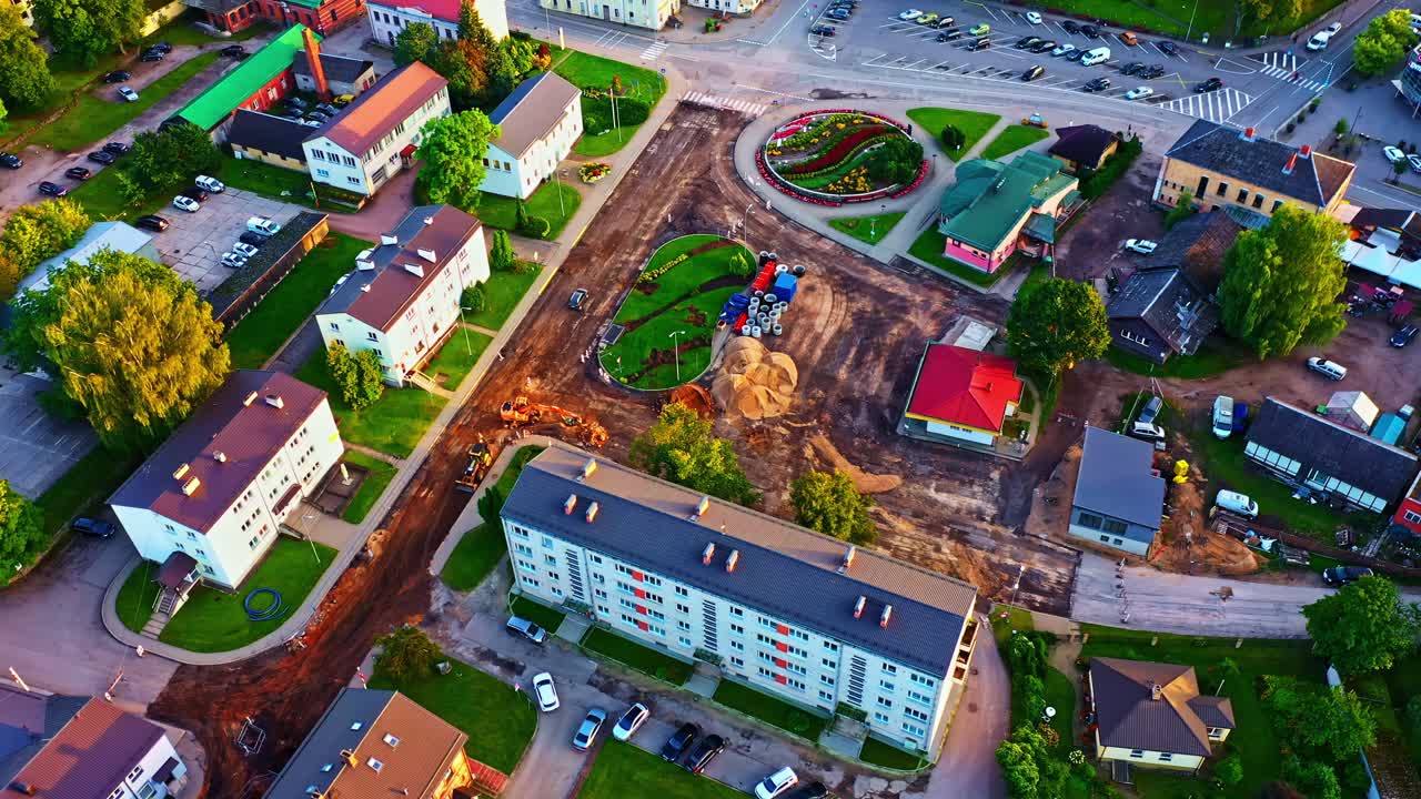 City center street reconstruction with flowerbed, playground, and apartment buildings in evening light