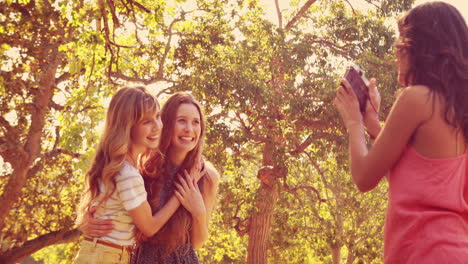 pretty brunette taking pictures of her friends with retro camera