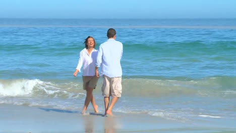 Cute-couple-playing-at-the-edge-of-the-water