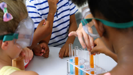 maestro ayudando a los niños en el laboratorio