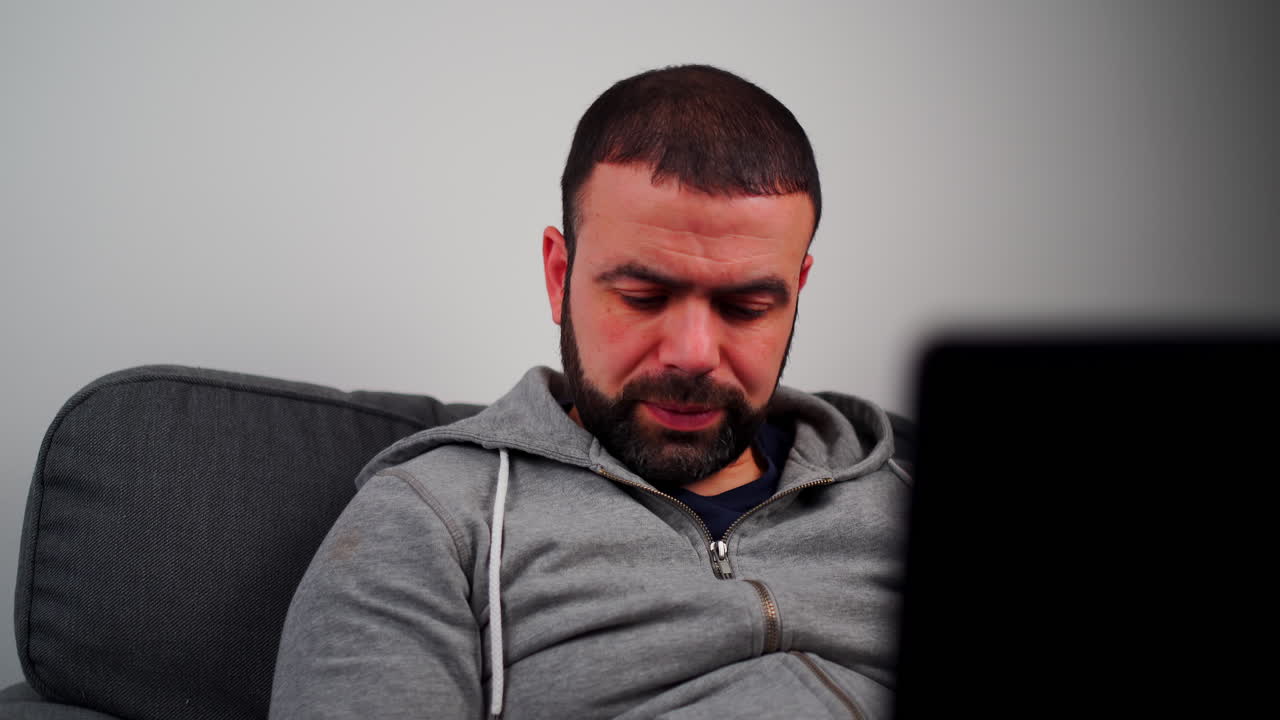 el hombre se molesta mientras trabaja en su portátil.