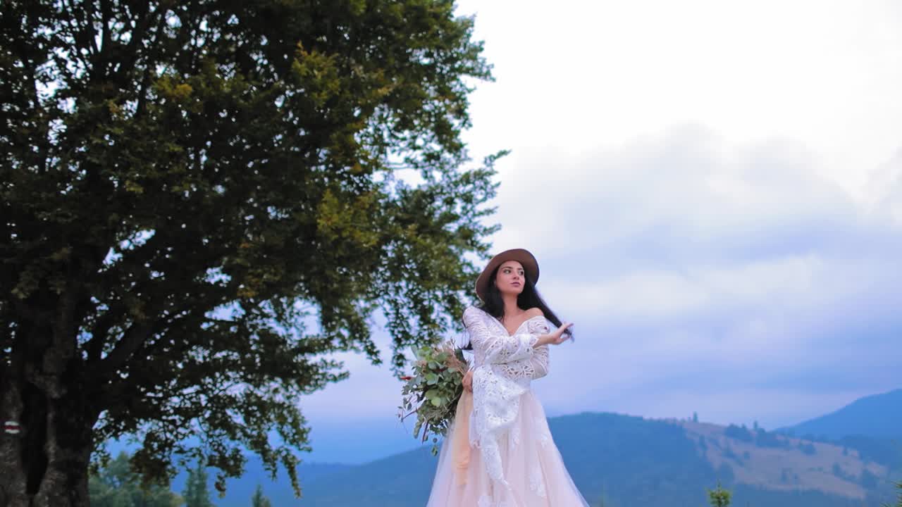 Bride in luxury dress posing outdoors. Beautiful bride in wedding dress posing on the mountains