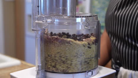 moler cebollas, frijoles, nueces, avena y hongos en un procesador de alimentos - cámara lenta