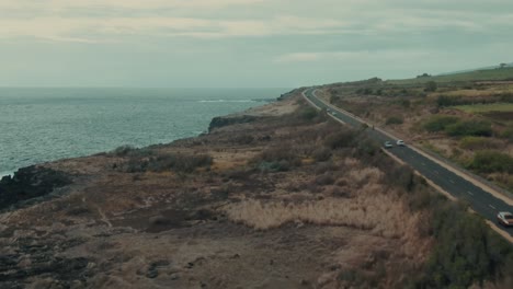 carretera costera aérea de 4k con tráfico cerca de acantilados volcánicos