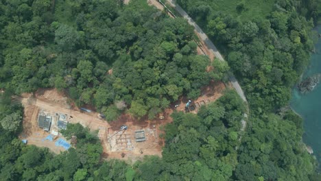 Vista-Aérea-De-Aves-No-Tripuladas,-Toma-Lenta-De-Camiones-A-La-Izquierda-De-Limpieza-De-Tierras-Y-Desarrollo-En-El-Bosque-Tropical-Junto-A-La-Costa-En-Una-Isla-En-Tailandia