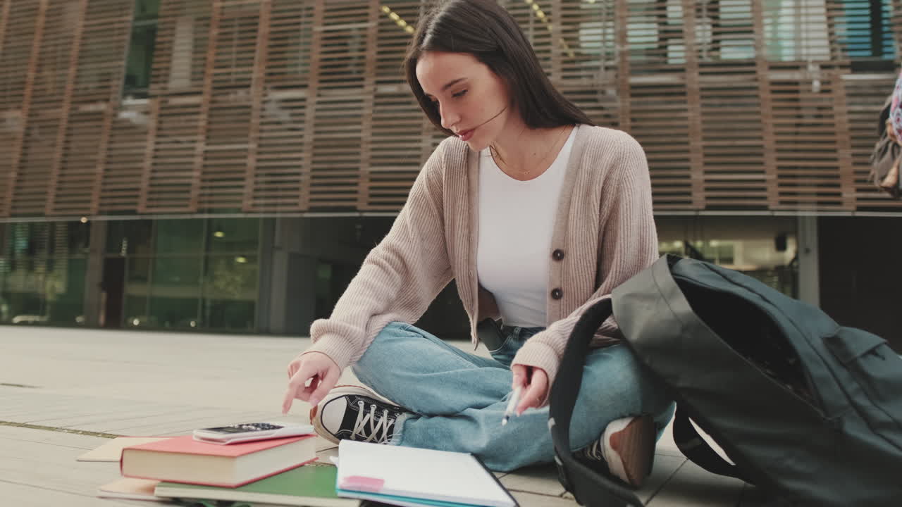 Uno studente seduto a terra che studia