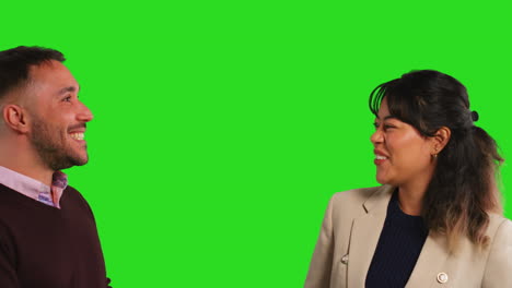 Close-Up-Studio-Shot-Of-Male-And-Female-Teachers-Or-Businesspeople-Laughing-Together-Against-Green-Screen