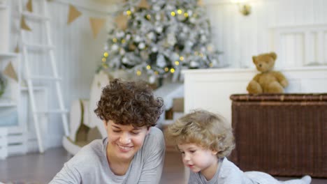 Glückliche-Mutter,-Die-Zu-Weihnachten-Mit-Ihrem-Sohn-Auf-Dem-Boden-Spielt