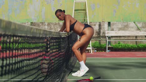 on a bright and sunny day, a girl in a thong bikini engages in a spirited game of tennis