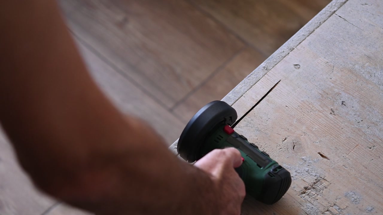 Sega circolare a batteria che taglia una tavola di legno in officina
