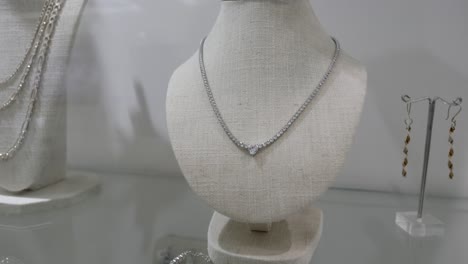 pendientes y collar de plata con diamantes exhibidos dentro de la joyería