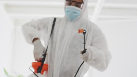 health worker wearing protective clothes cleaning the office using disinfectant