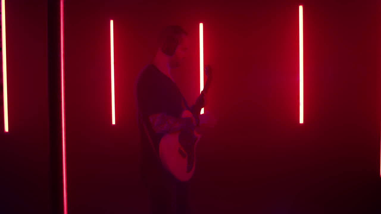 Musician Playing Guitar in Neon Blue Studio